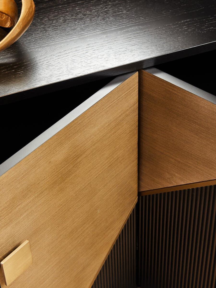 Close up of wooden sideboard cabinet with dark top and gold square handles