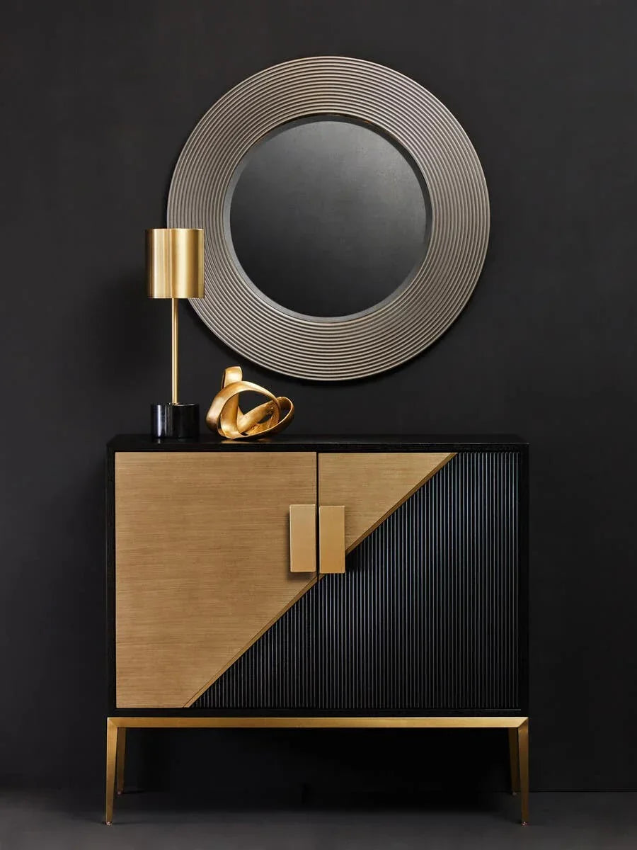 Gold and black sideboard with geometric pattern, round wall mirror and metallic lamp