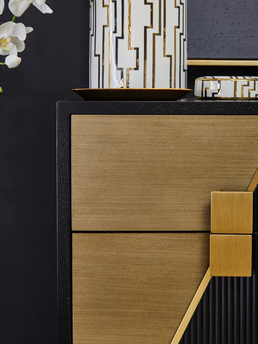Contemporary sideboard with gold textured drawers, black frame, and geometric handles