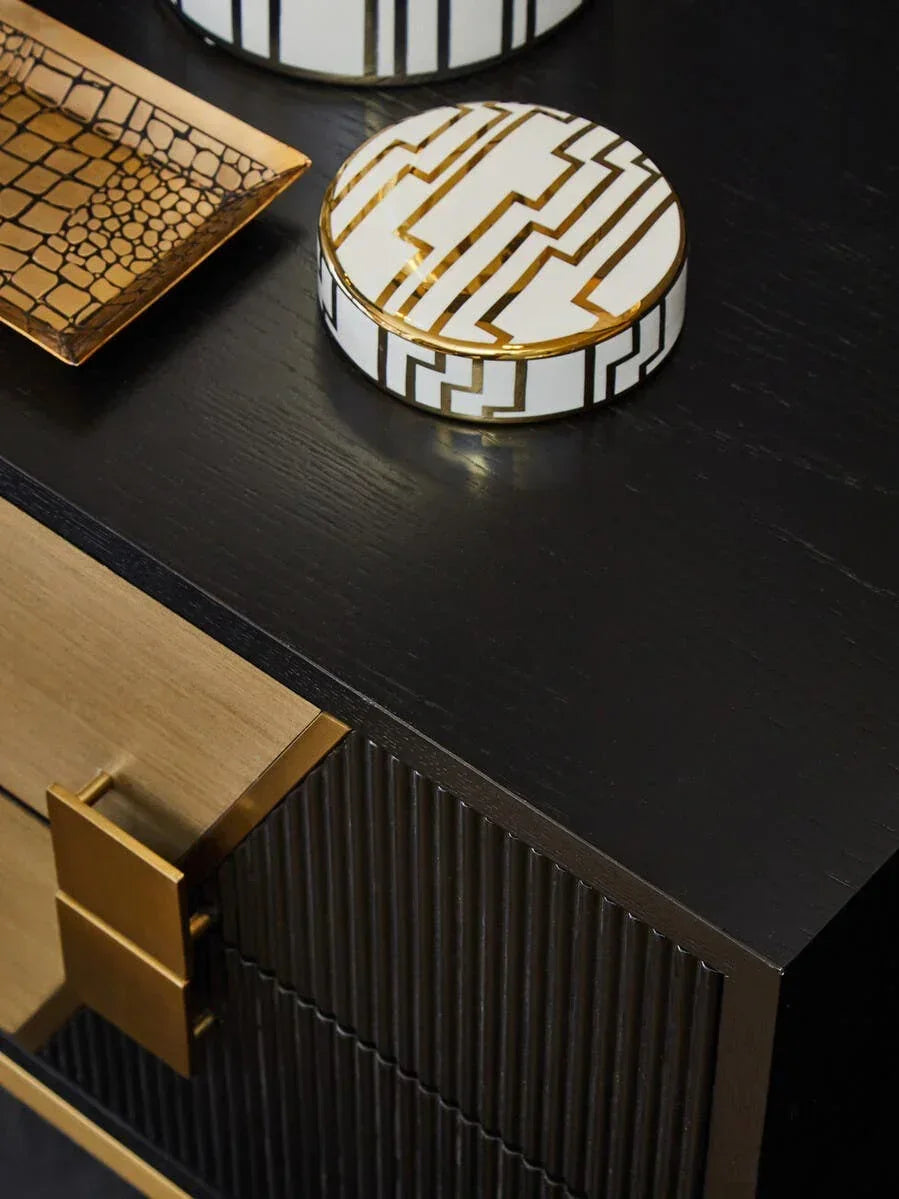 Black sideboard with gold handles and decorative tray and box on top