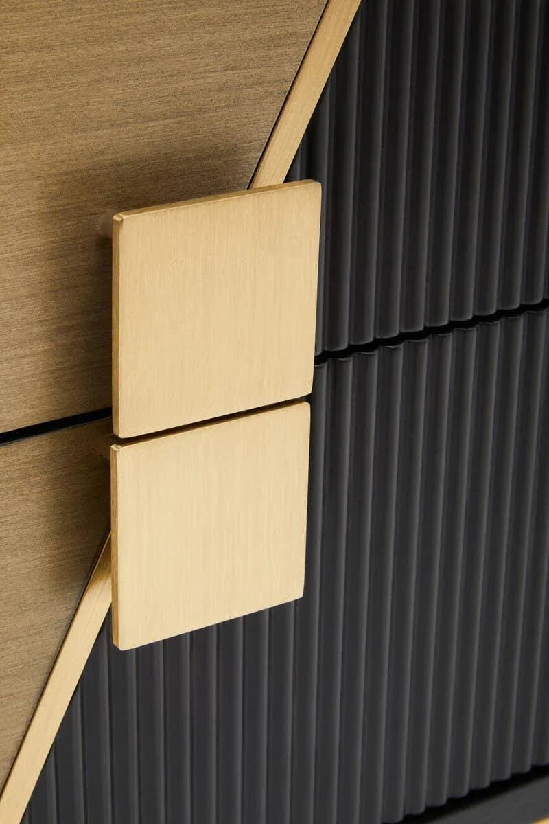 Modern cabinet handle in brushed gold on textured black and wood grain cabinet front