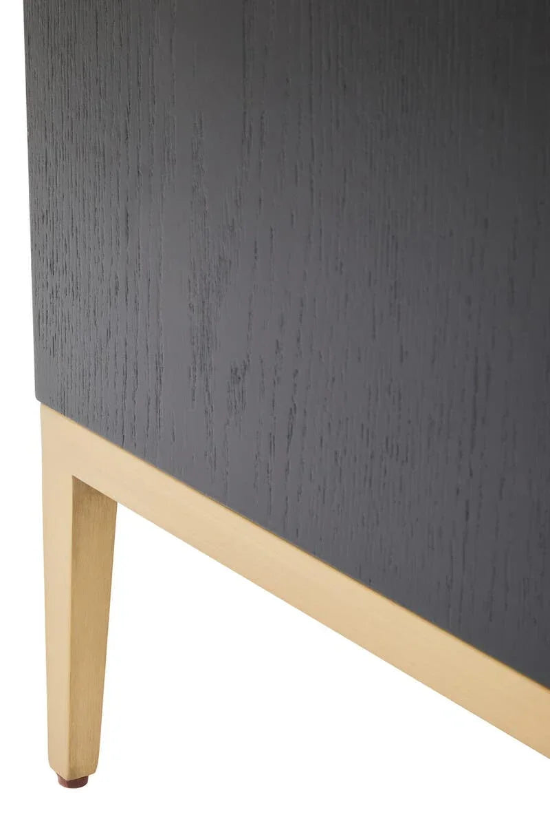 Closeup of black wood cabinet corner with light oak furniture leg