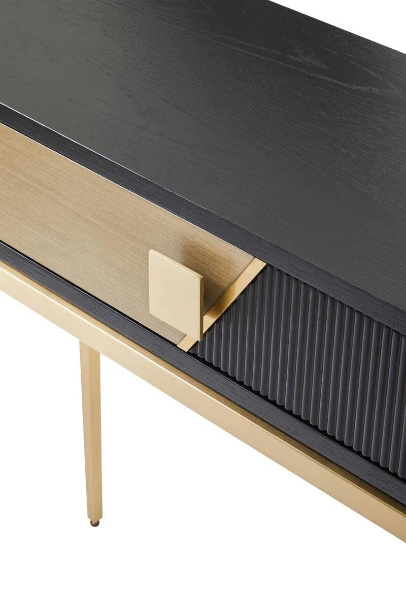 Close-up of black and gold console table with ribbed drawer detail and square handle