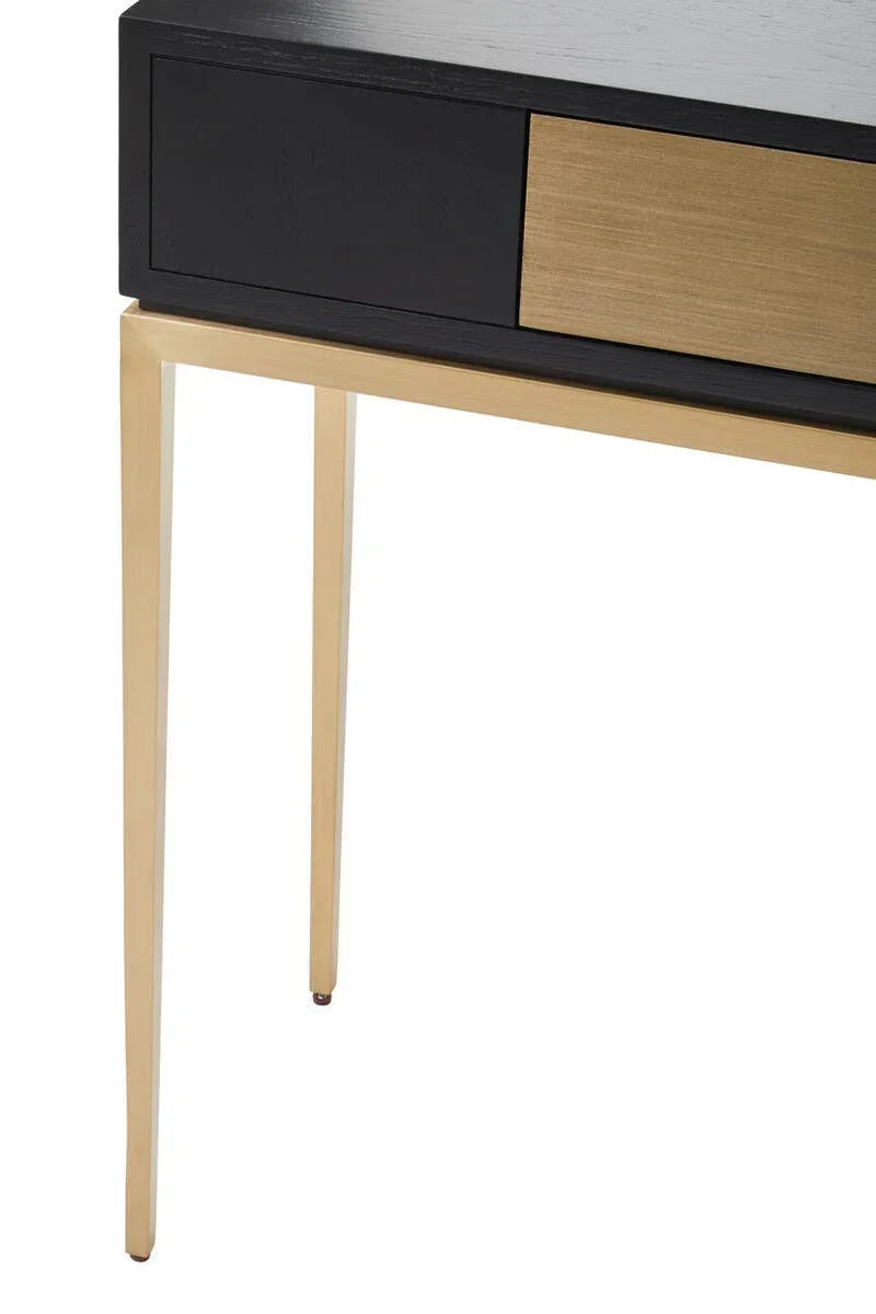 Modern console table with black and gold drawer front, slim gold metal legs, close-up view