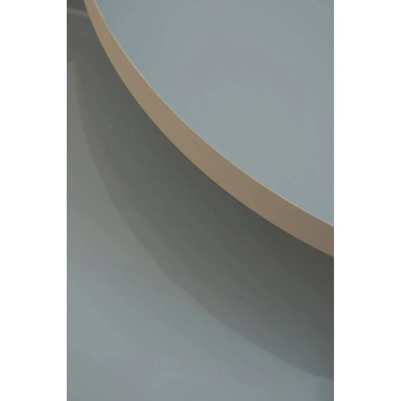Close-up of modern round coffee table with light beige edge and smooth grey surface