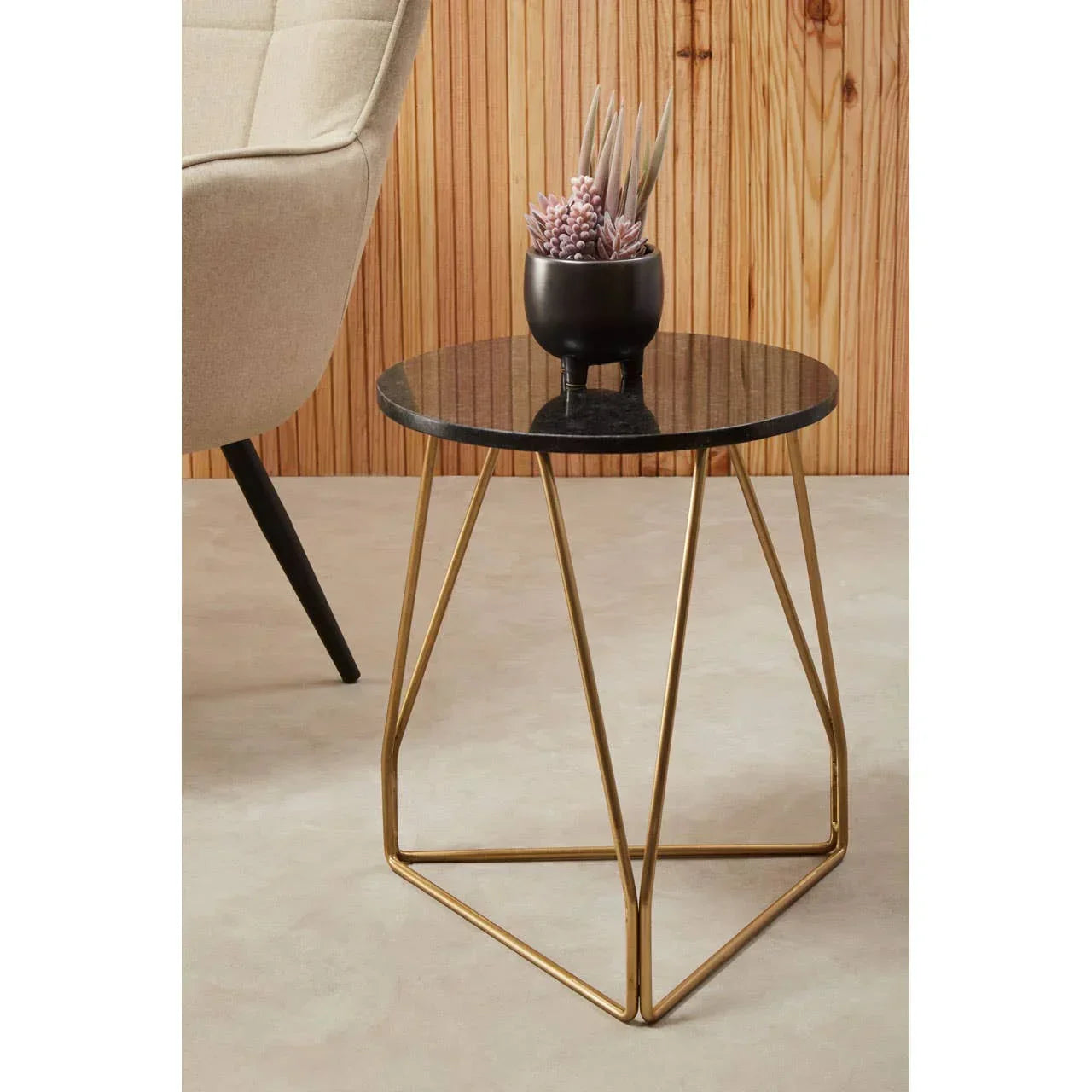 round black marble side table with gold metal legs and potted plant, modern living room