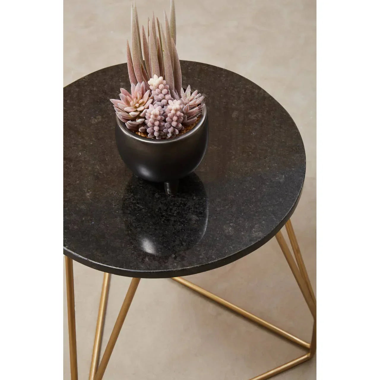 round black marble side table with gold legs and potted faux succulents on top