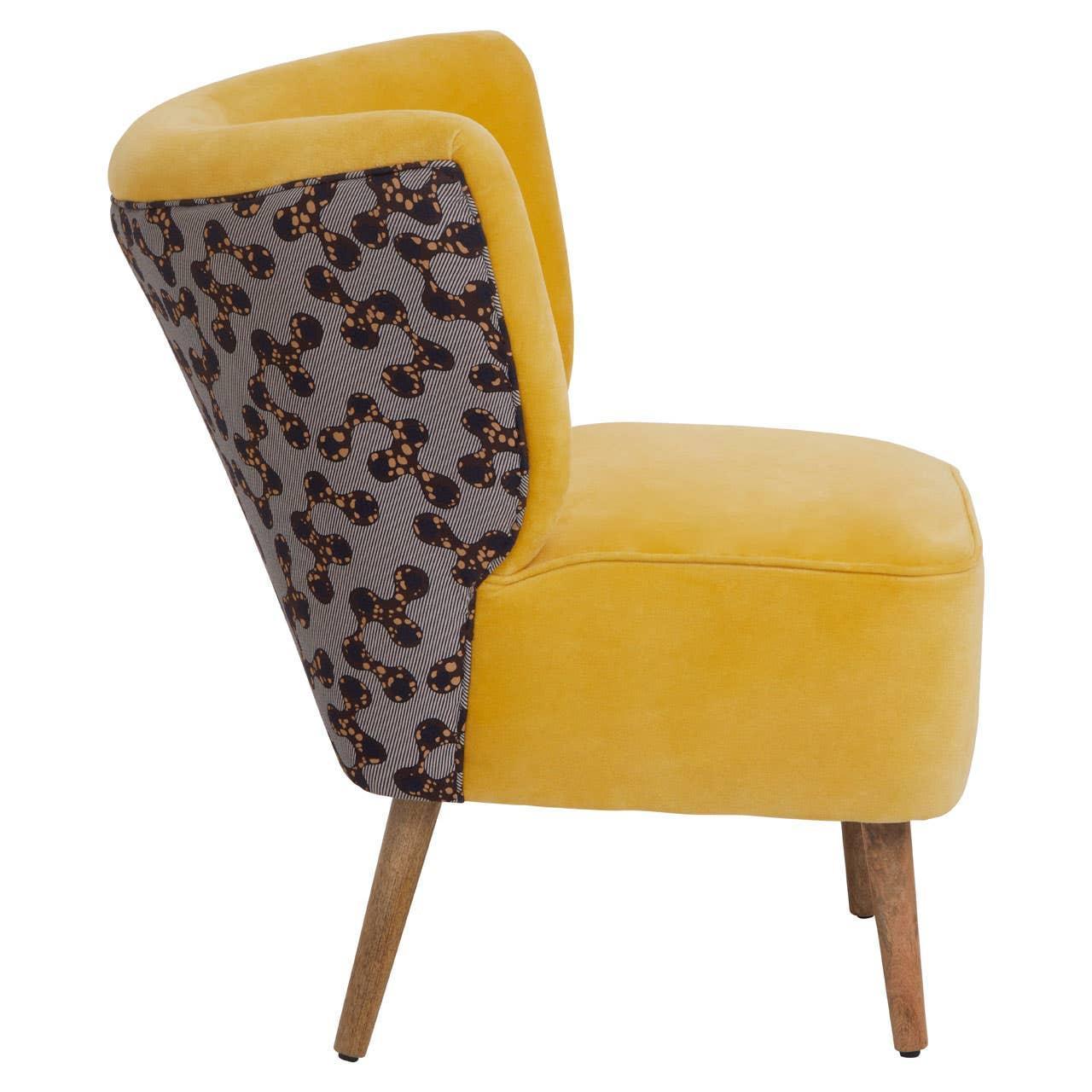 Yellow accent chair with patterned fabric backrest and wooden legs, side view