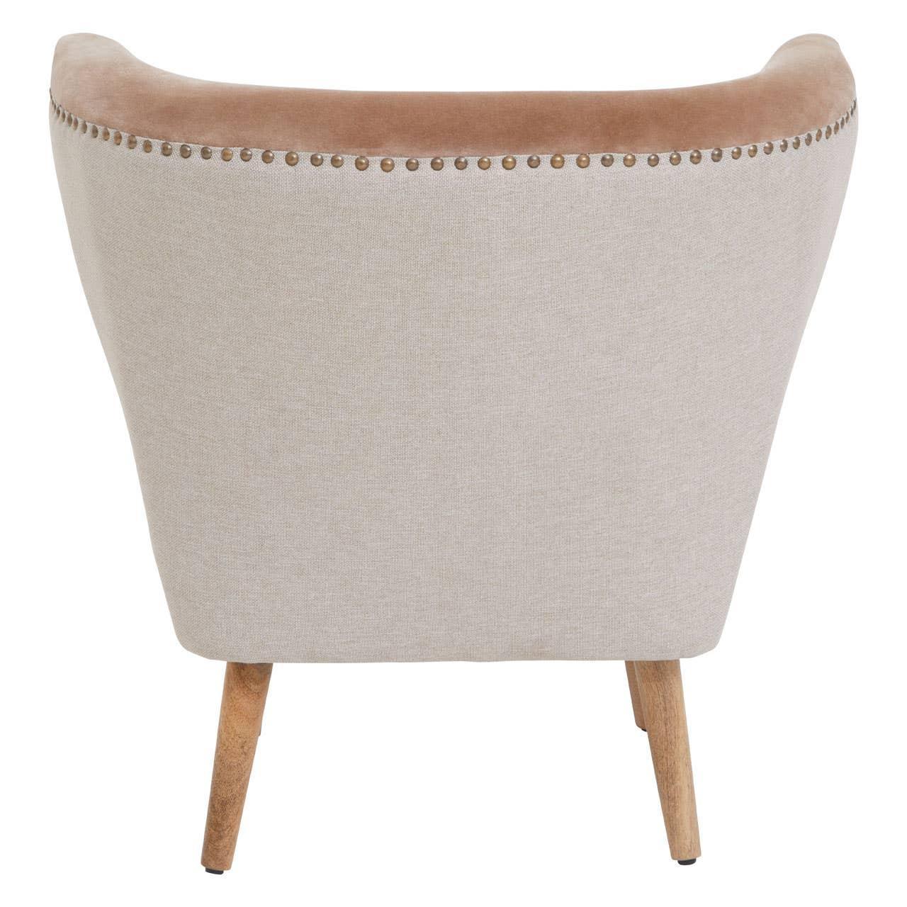 Beige accent chair with curved back, velvet trim, nailhead detail, and wooden legs rear view