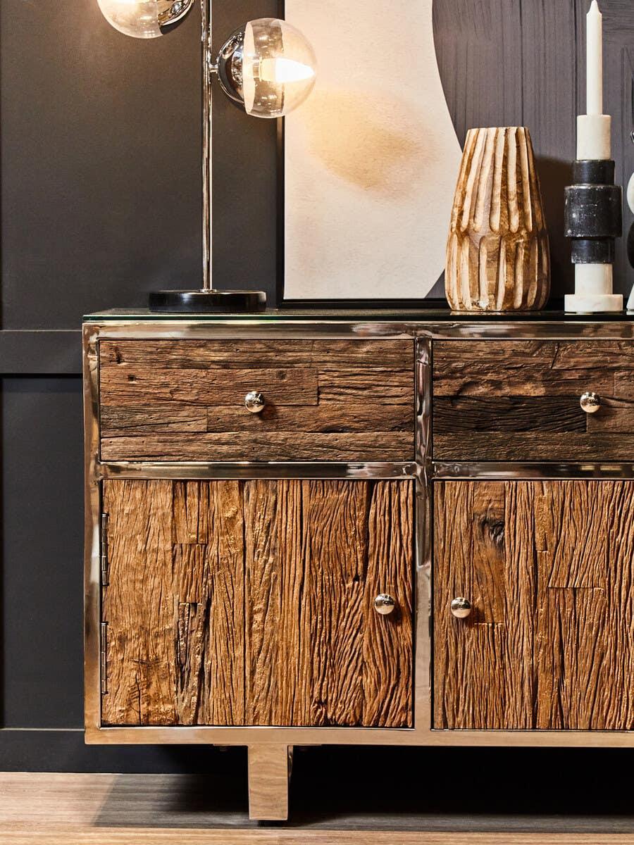 Rustic wood sideboard with metal frame and drawers, styled with lamp and ceramic vase