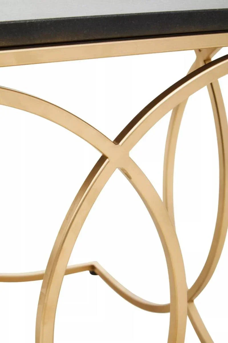 Gold metal coffee table base with curved geometric design and black tabletop detail