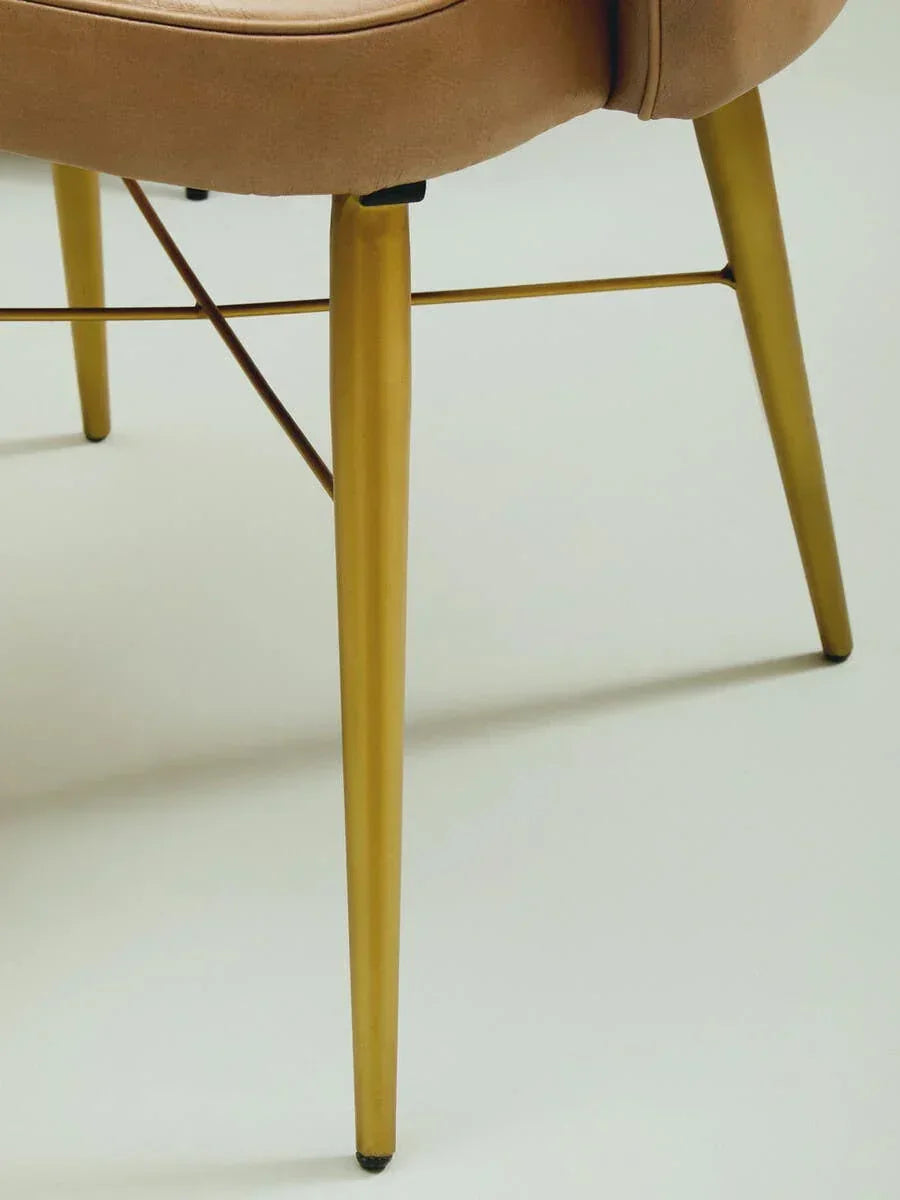 Beige dining chair with gold metal legs and supportive crossbar detail