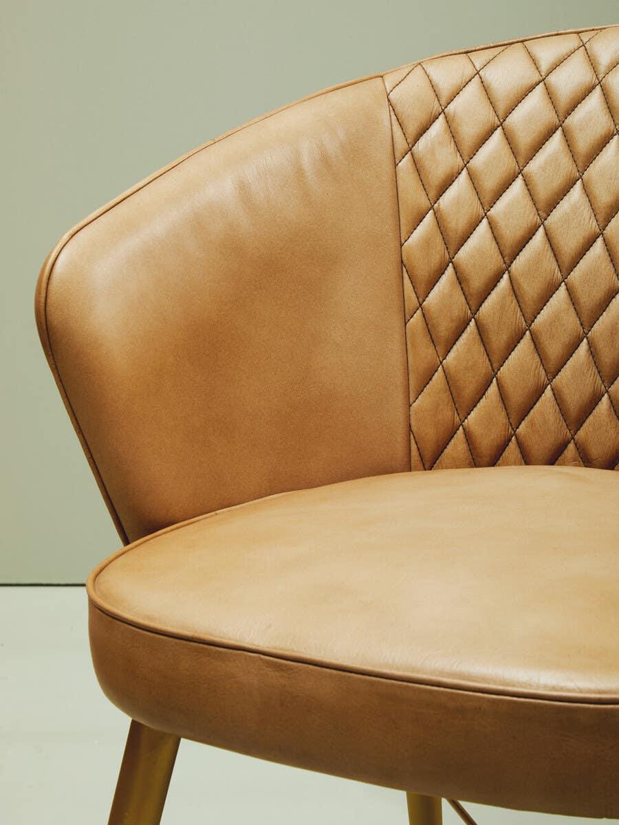 Tan leather dining chair with quilted backrest and smooth seat detail