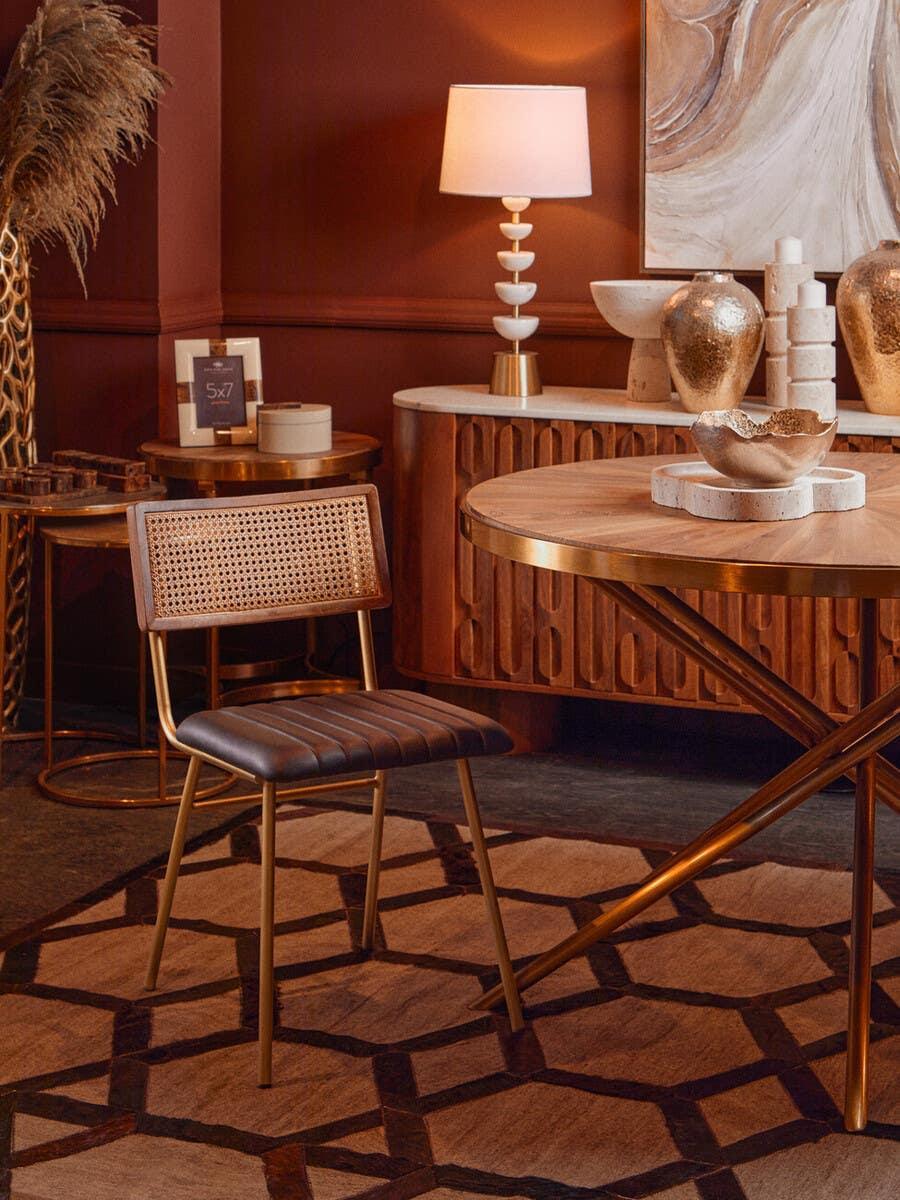 Wood dining table and brown cushioned chair with woven back in a modern room