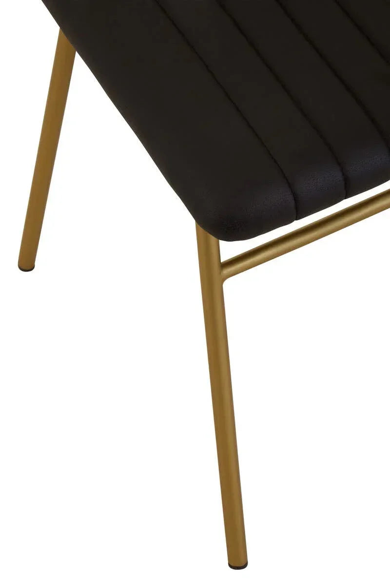 Black dining chair with stitched seat and gold metal legs, close view