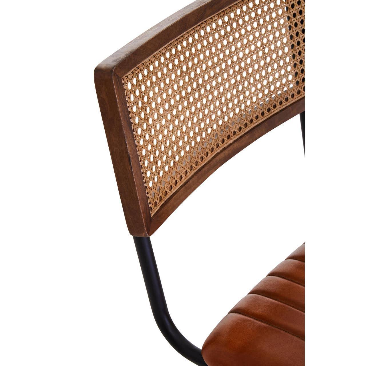 Close-up of dining chair with rattan backrest, black frame, and padded brown seat