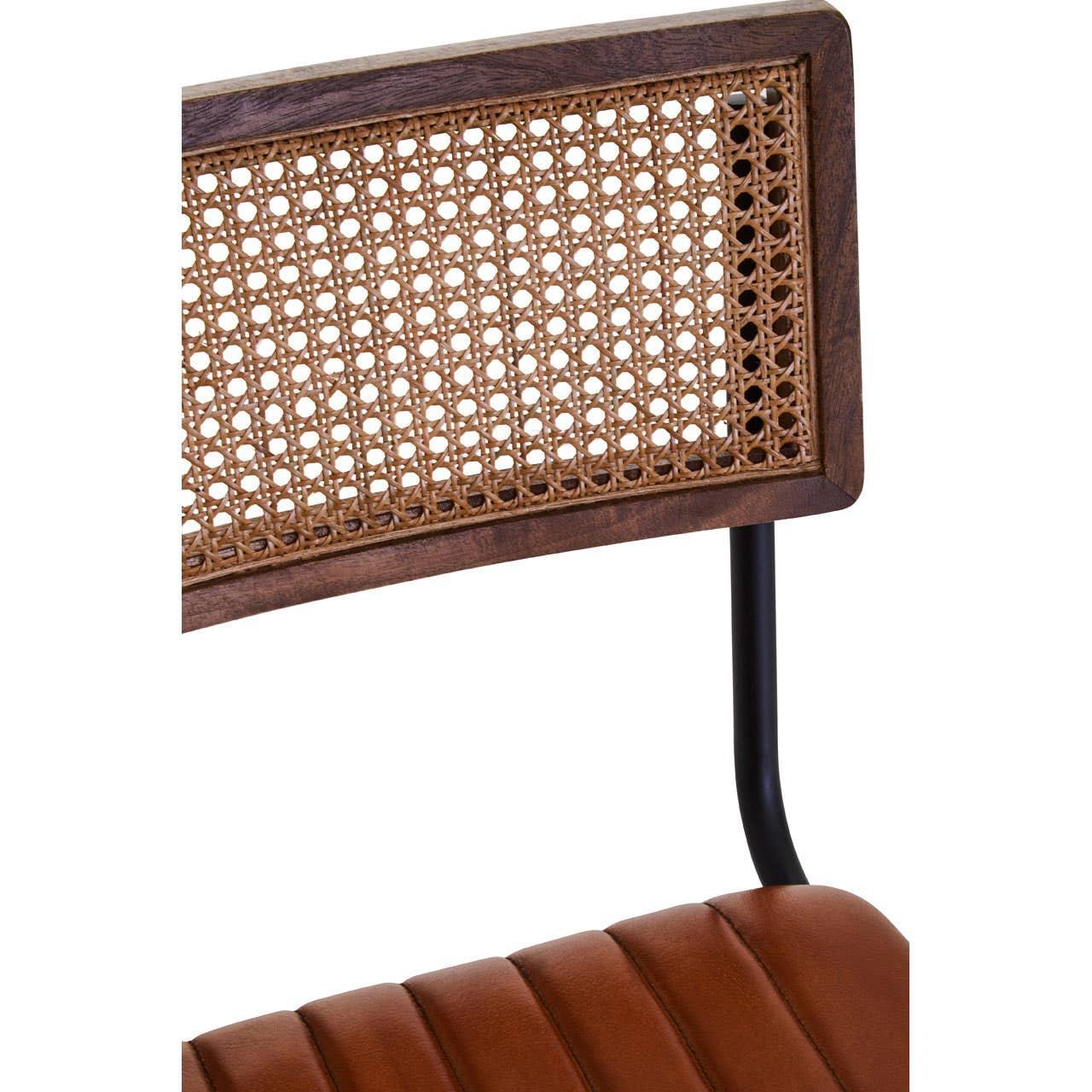Detail of rattan chair backrest with brown leather seat and black metal frame