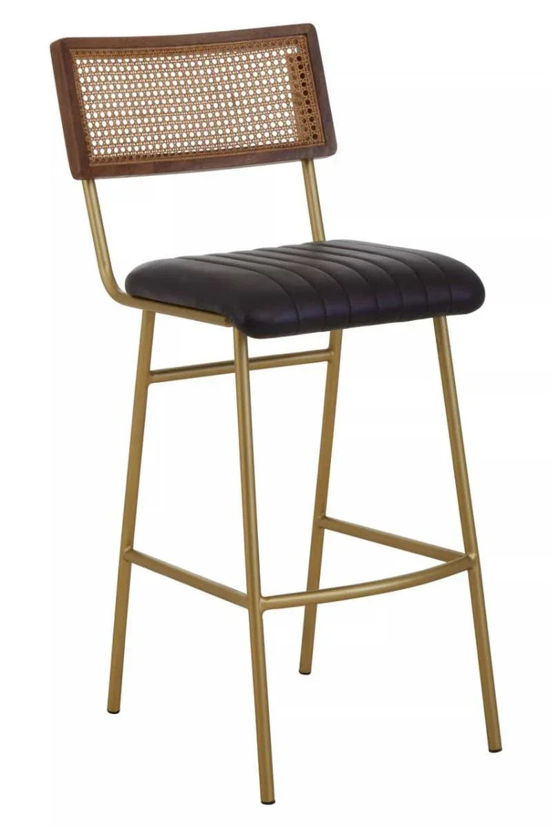 Bar stool with gold frame, black padded seat, and cane backrest