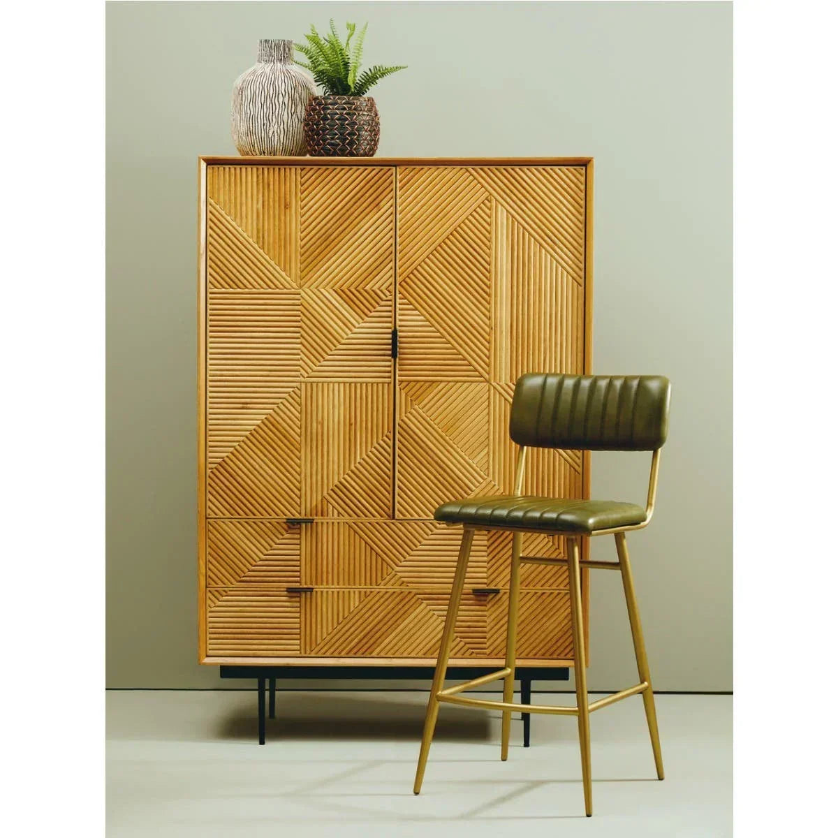 Patterned wooden cabinet with black legs and green barstool, decorative vases on top