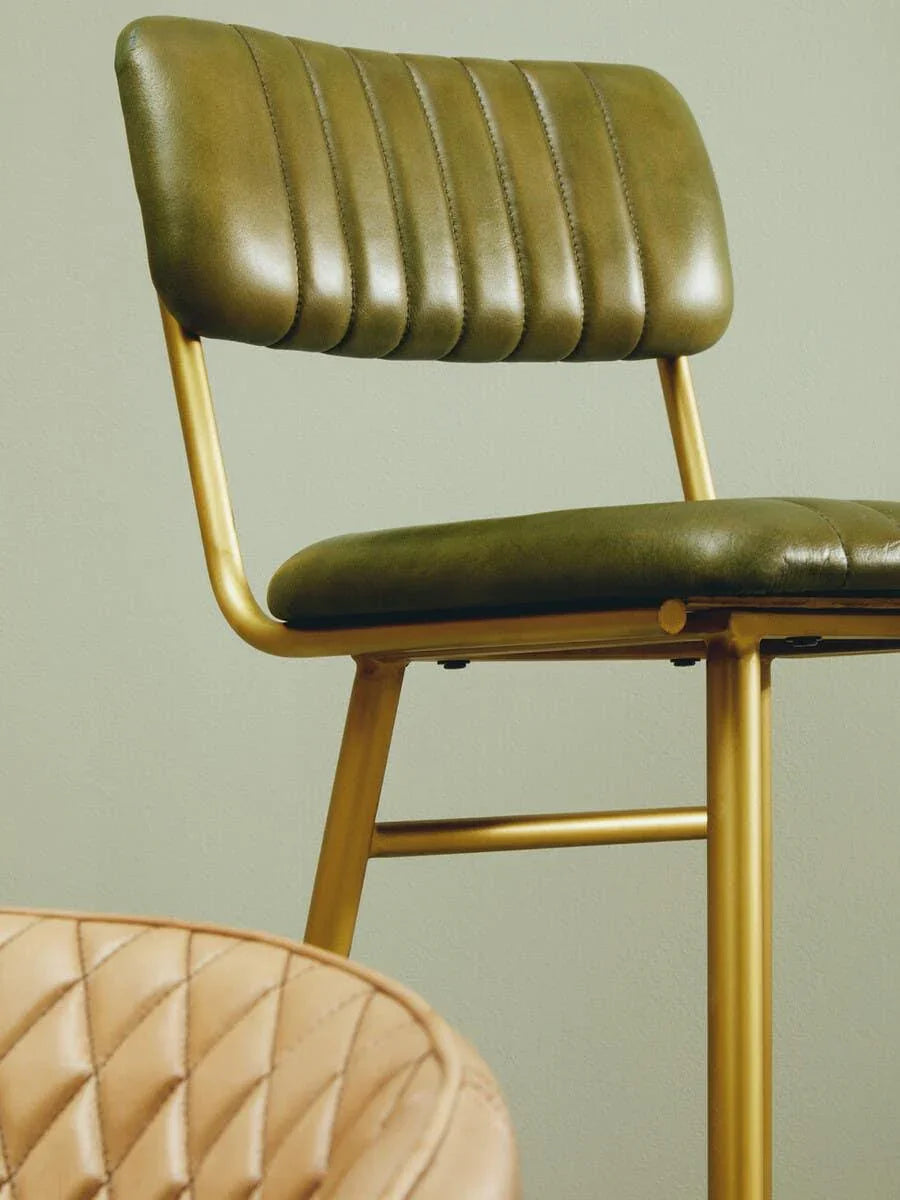 Green leather dining chair with gold metal legs and stitched backrest detail