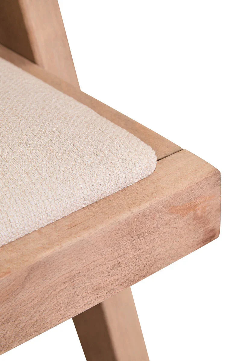 Closeup of beige fabric dining chair seat with light wood frame and angled leg