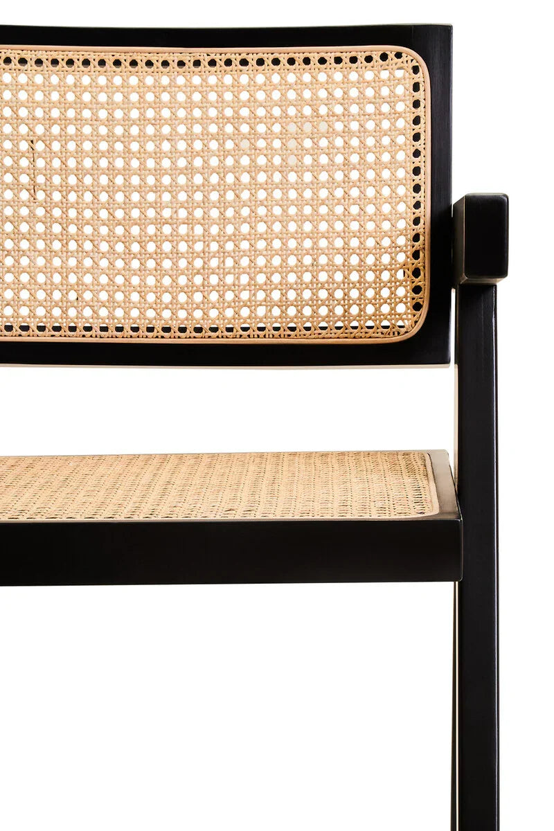 Black wood dining chair with woven cane seat and backrest, close-up angle
