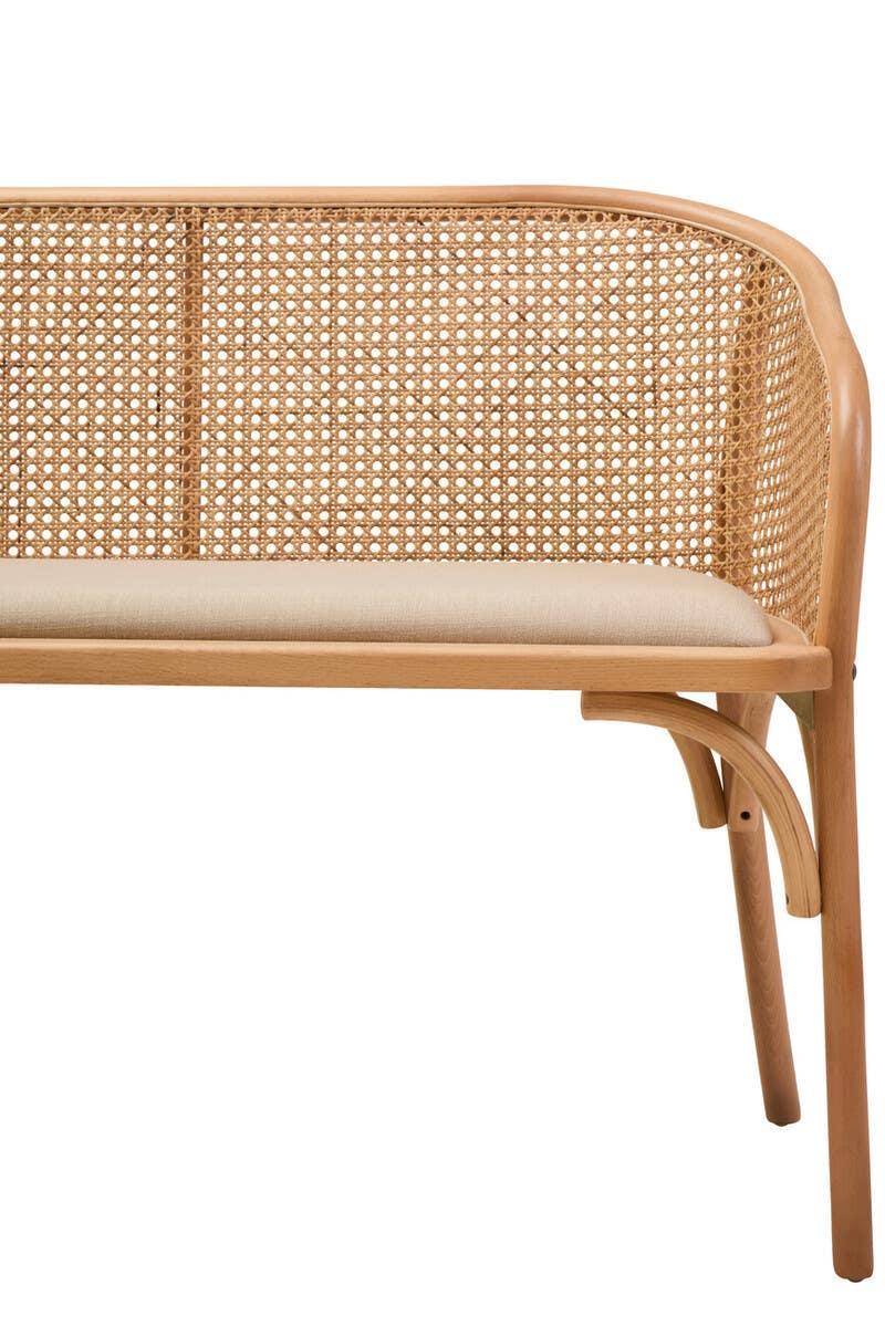 Cane back wooden bench with curved frame and cream upholstered seat