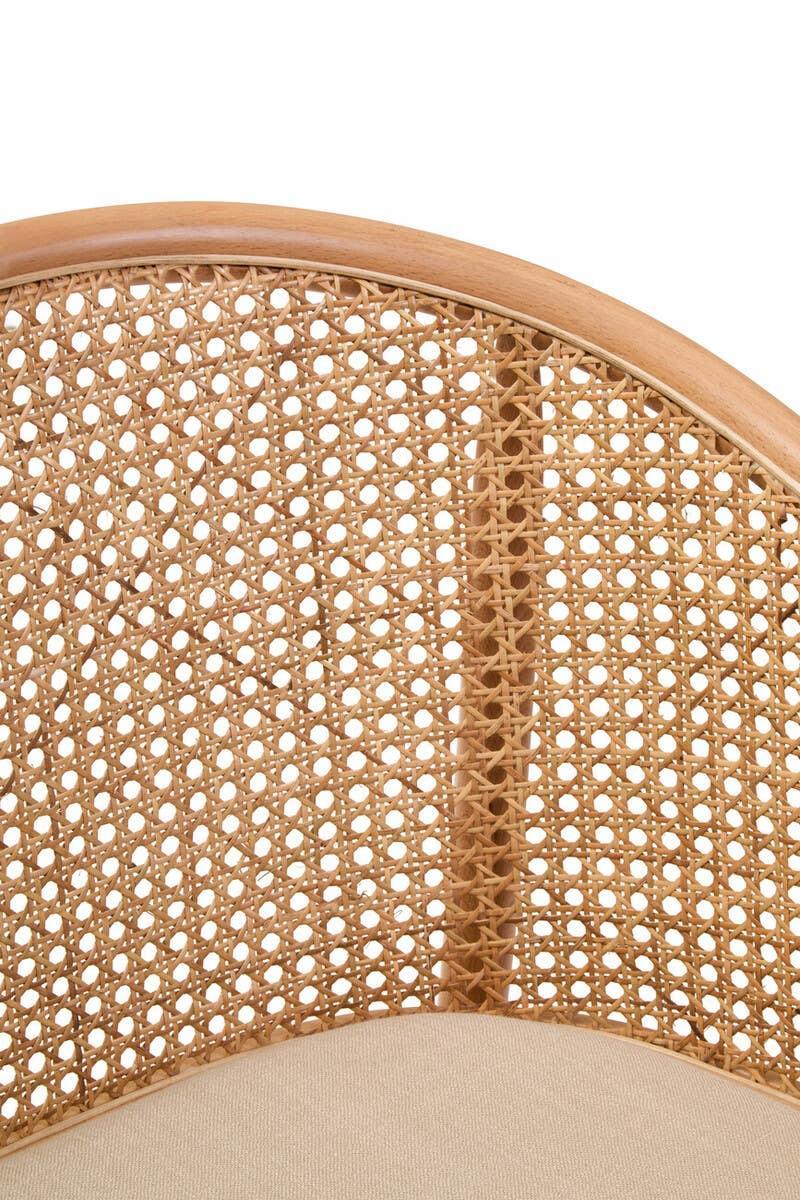 Close up of rattan chair backrest with woven cane pattern and curved wooden frame