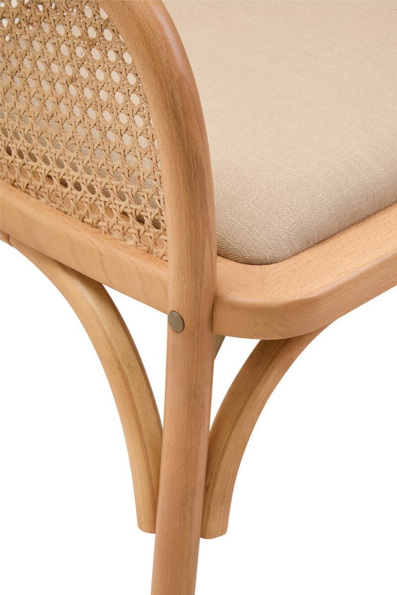 Wooden chair with cane backrest and beige fabric seat close-up