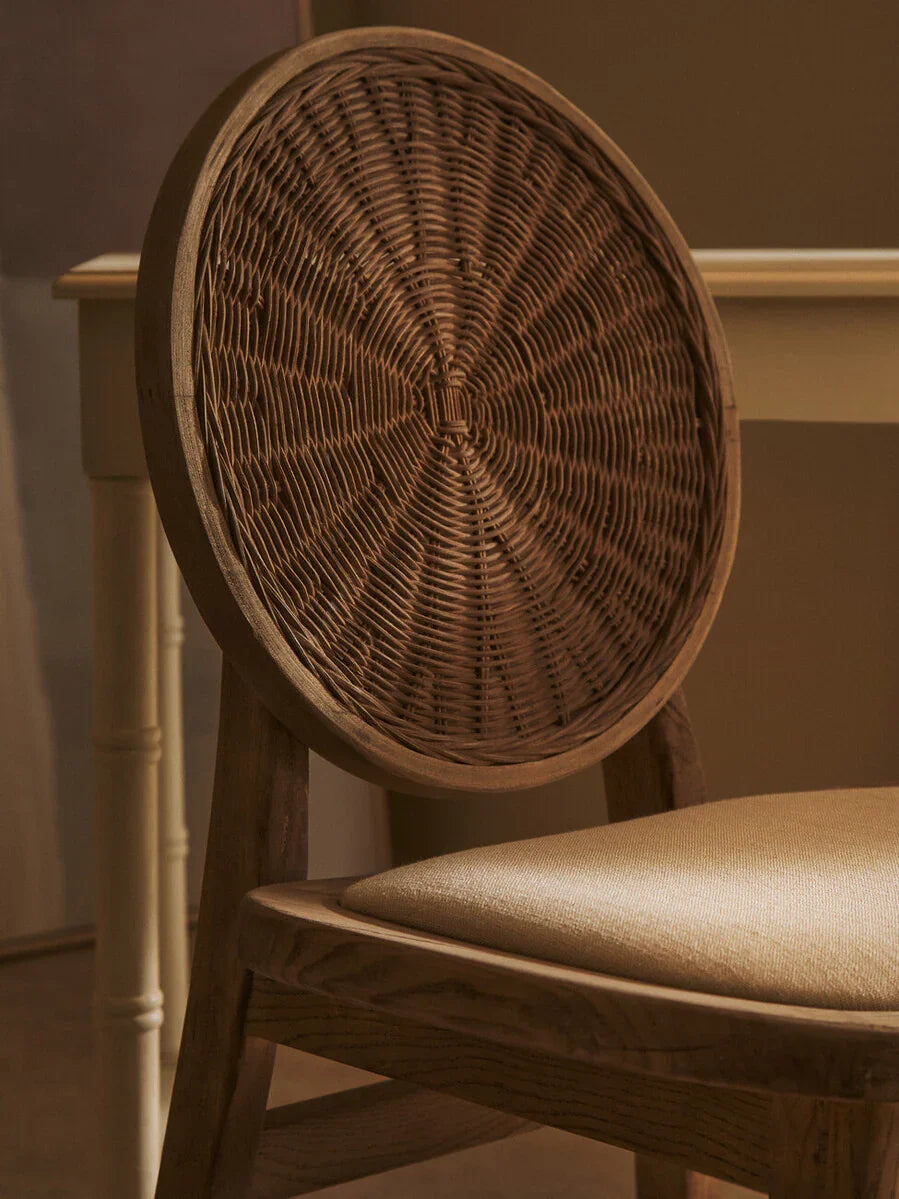 Wood dining chair with round woven rattan backrest and beige cushioned seat