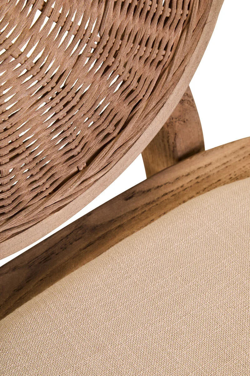 Close up of woven rattan chair back and beige fabric seat cushion