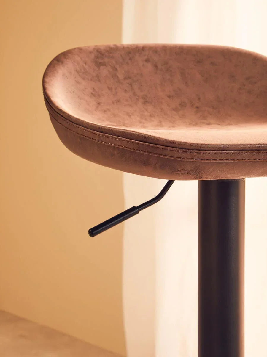 Close-up of brown faux leather bar stool seat with black adjustable lever and metal base