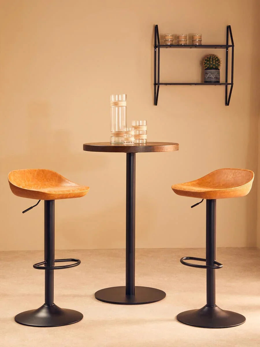 Two tan bar stools with black metal bases and round pub table in modern kitchen setting