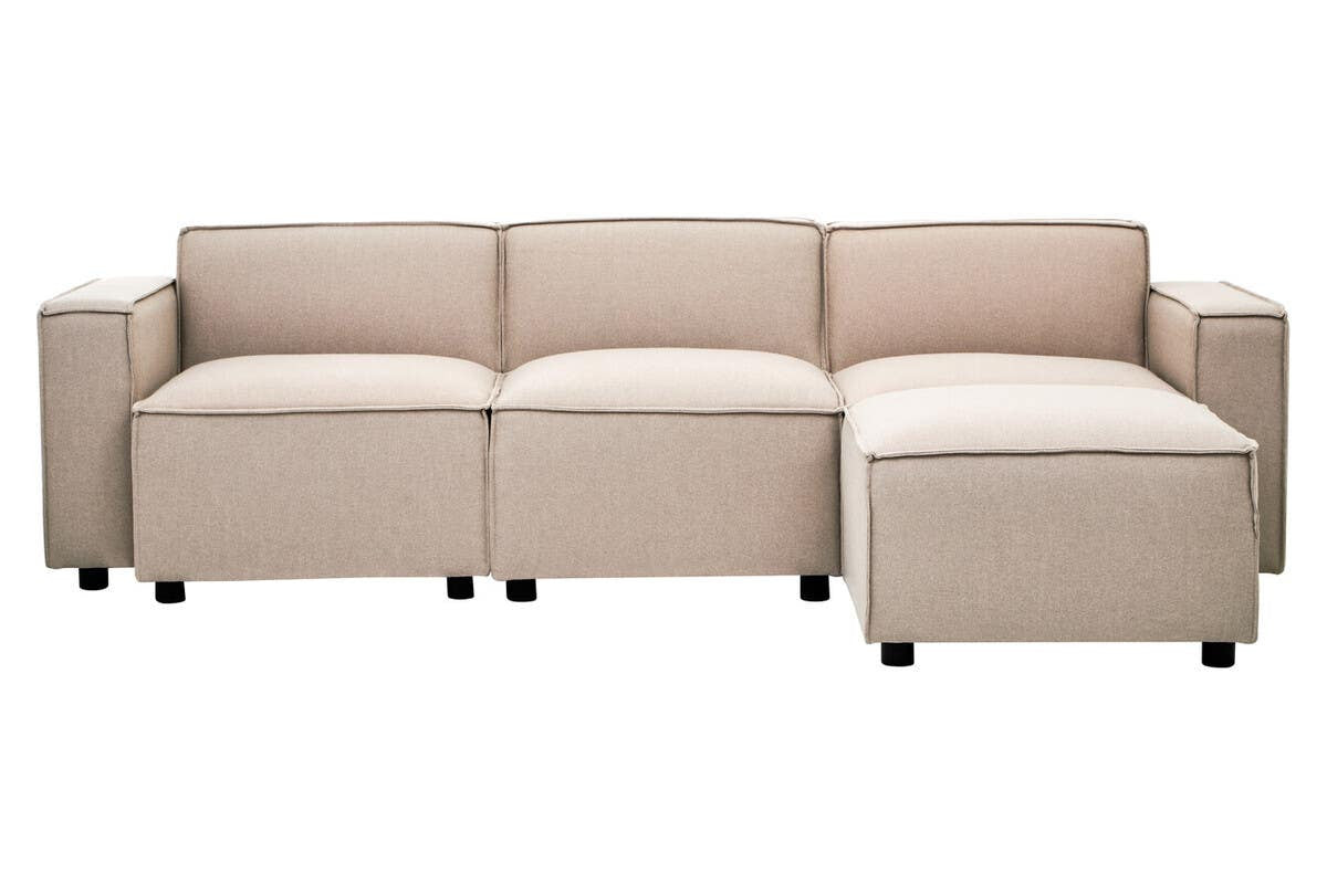 A modular sofa featuring a natural fabric upholstery in a light beige color, designed without arms for a sleek look. The sofa consists of three connected sections and a chaise lounge on one end, all resting on small black wheels for easy mobility. The overall design is modern and minimalist, suitable for various interior styles