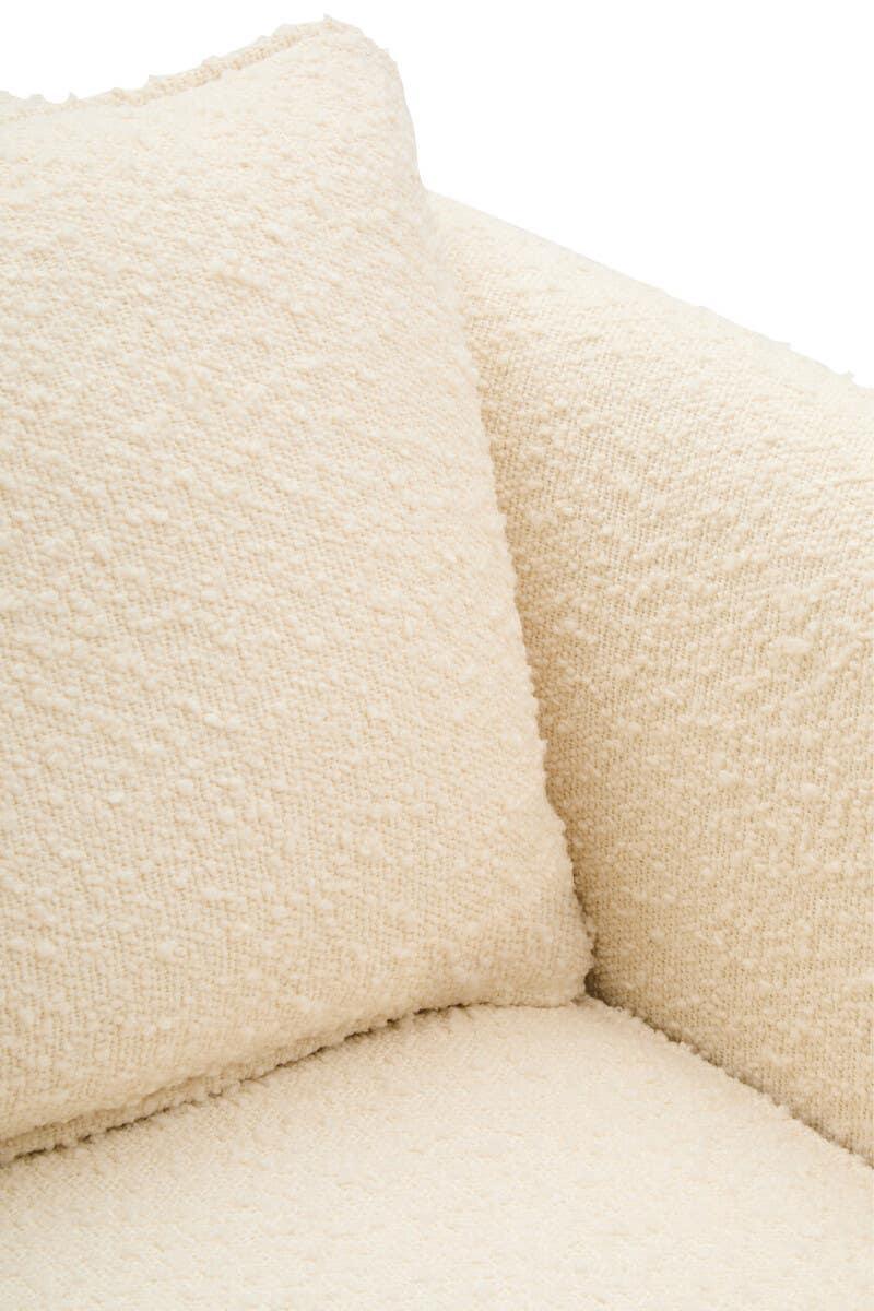Close-up of cream textured sofa fabric with matching cushion on seat and armrest