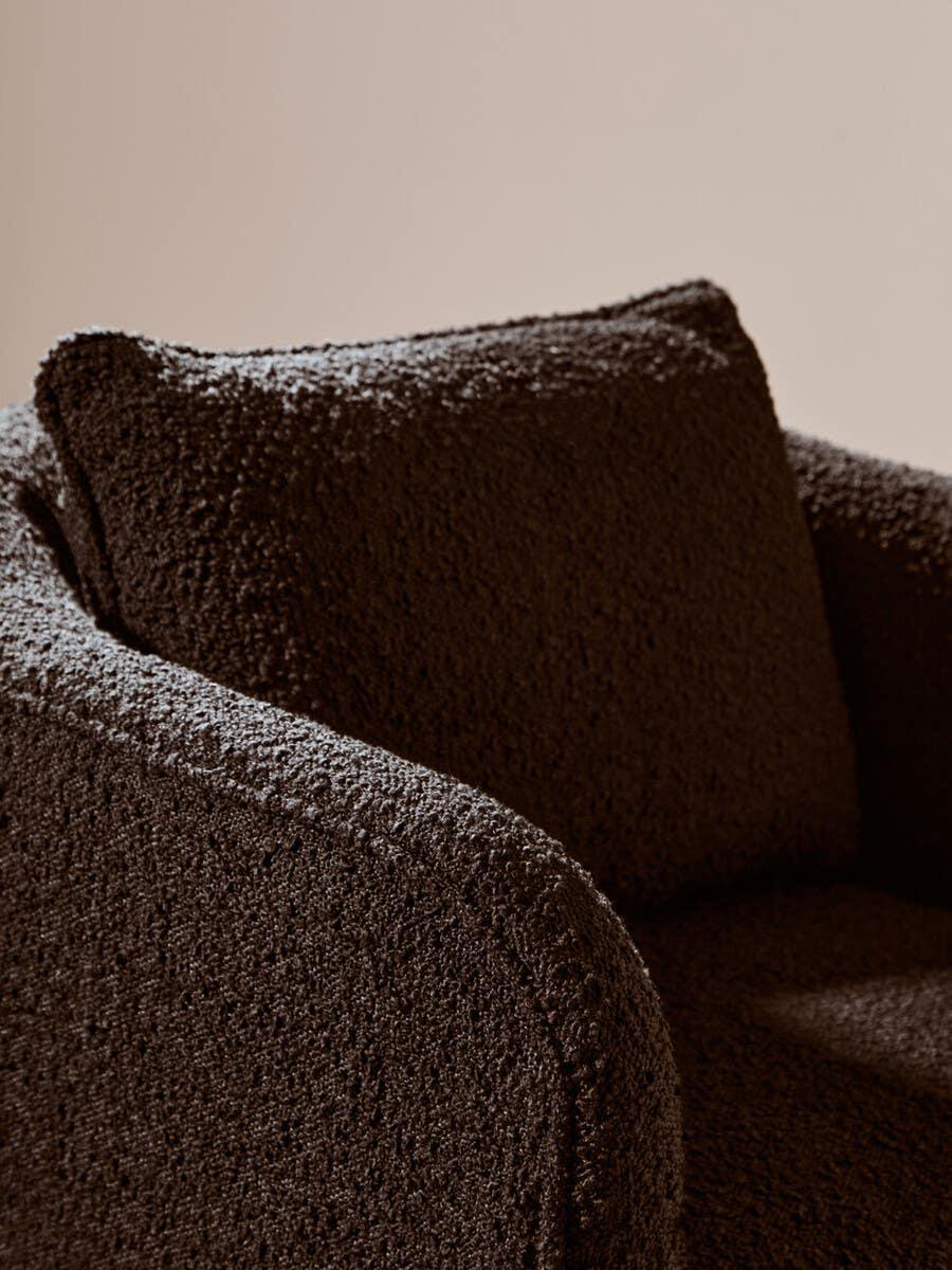 Close-up of brown boucle sofa arm and cushion