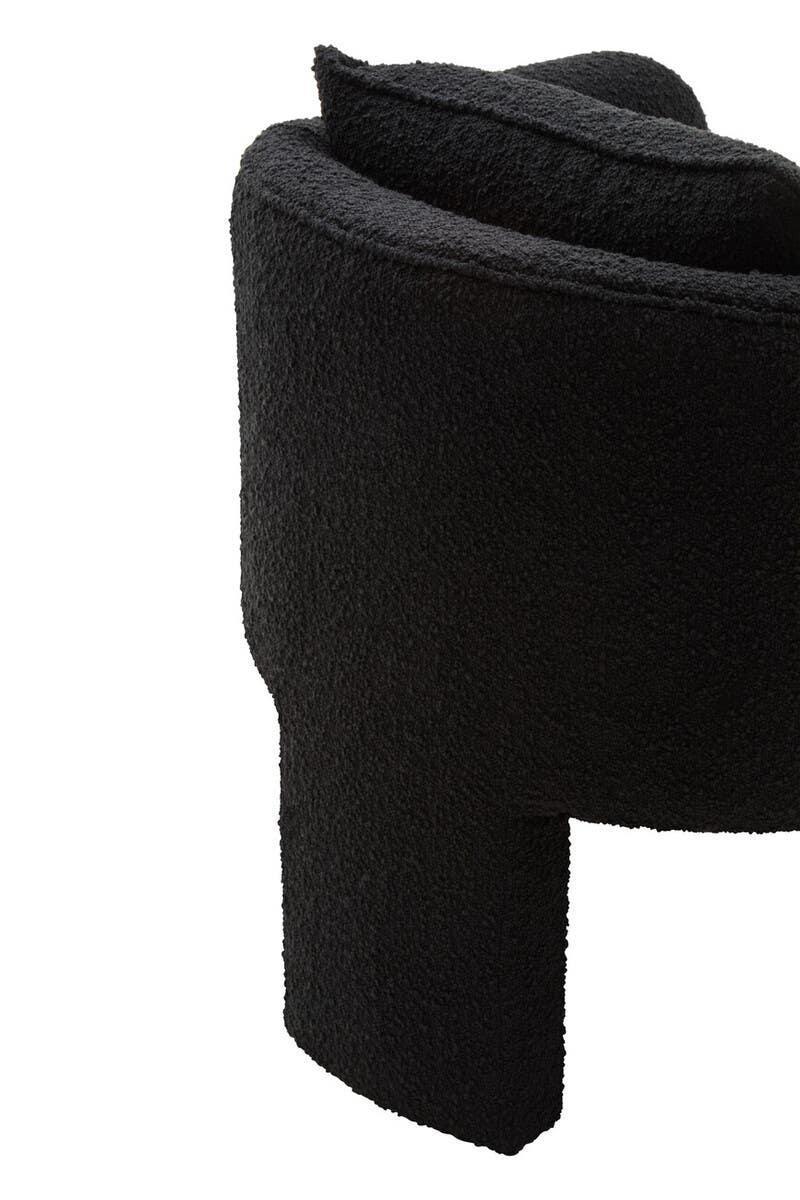Curved black boucle accent chair with textured upholstery, close-up of arm and backrest