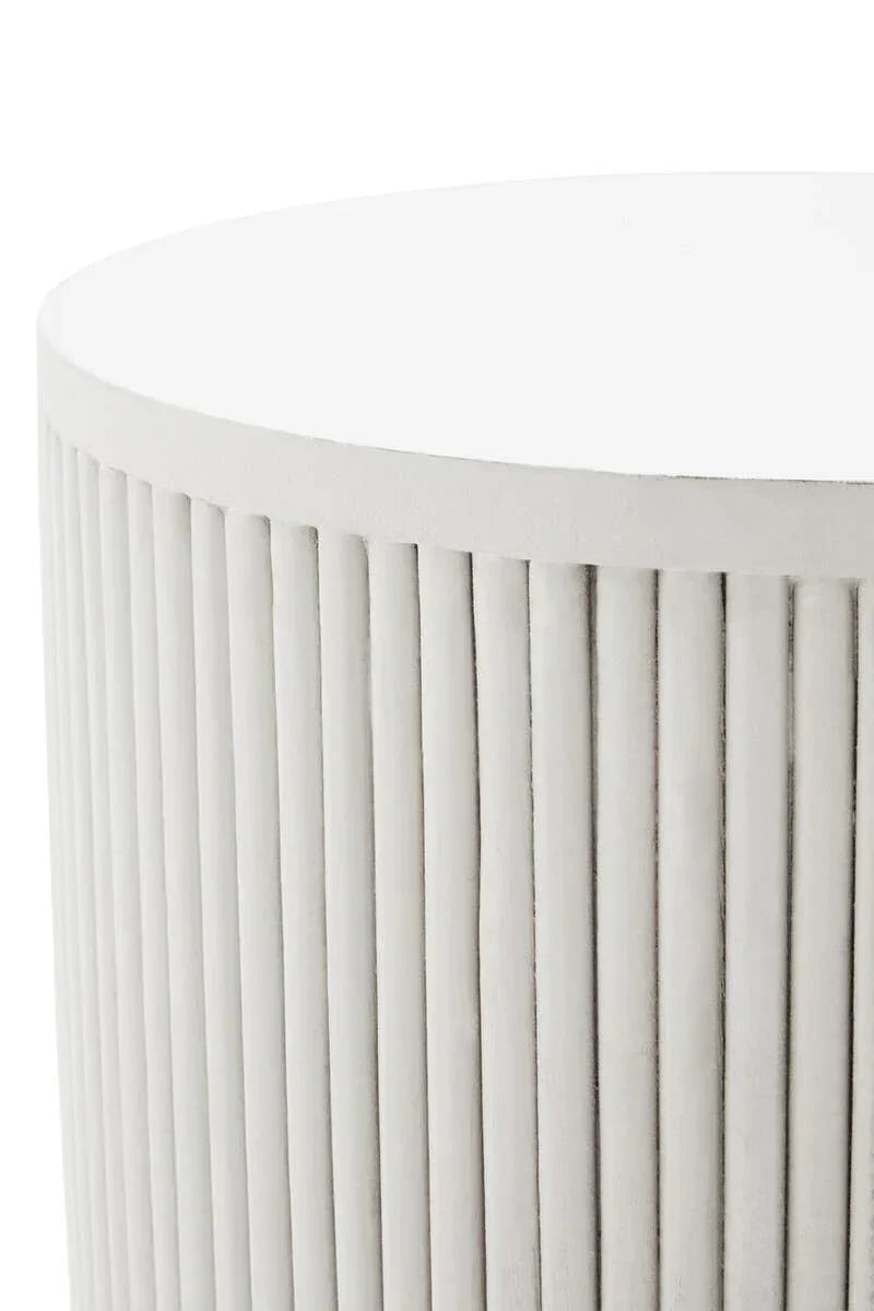 Round ribbed white side table with vertical grooves, close-up of concrete finish