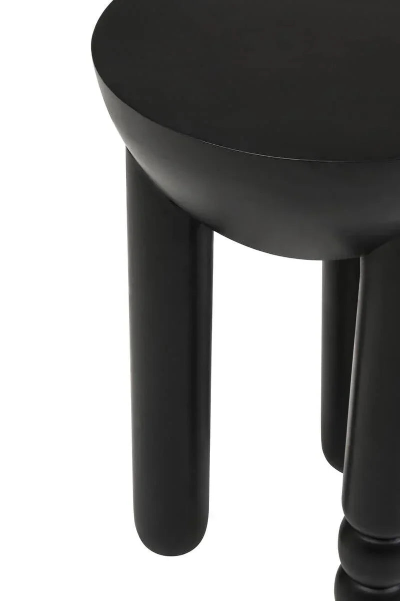 Black side table with round top and chunky cylindrical legs, close-up view