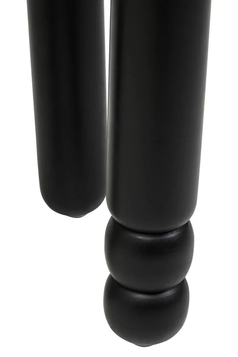 Close-up of black wooden furniture legs with a rounded design detail