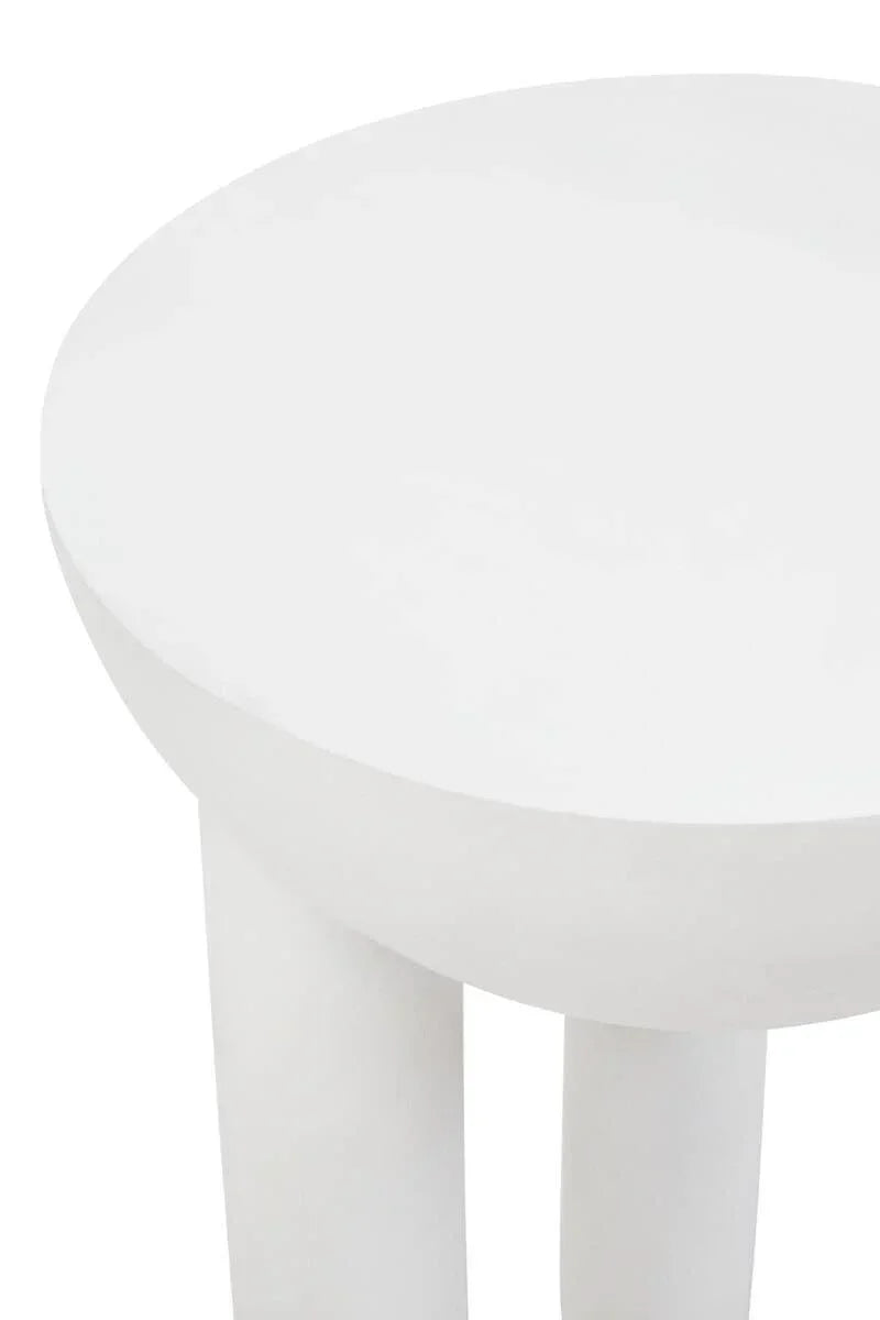 Closeup of round white side table with smooth finish and thick cylindrical legs