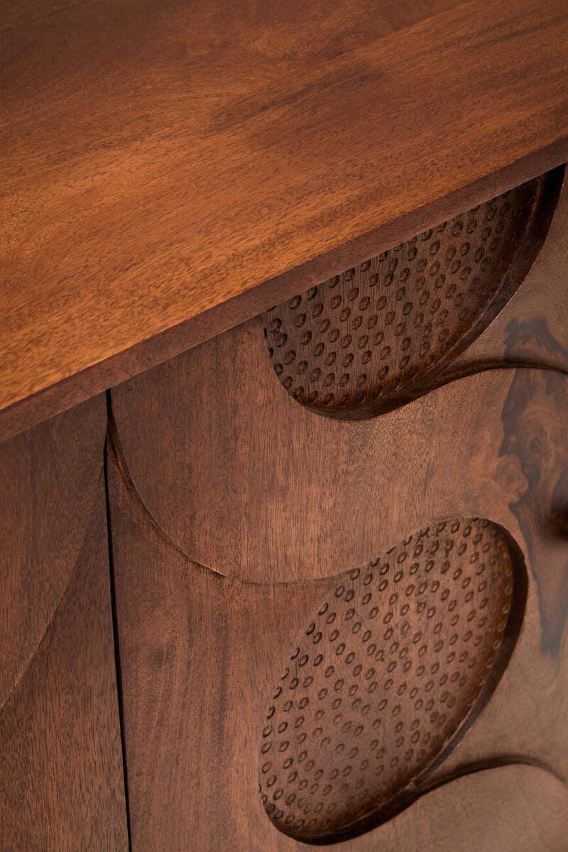 Walnut wood cabinet with circular carved textured door detail, close-up view