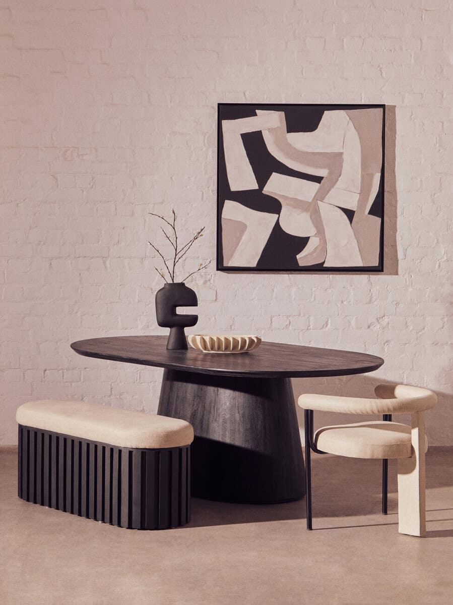 Modern dining table set with dark wood oval table, cream bench, chair and abstract wall art