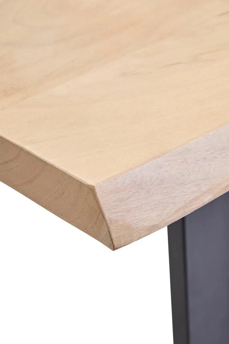 Close-up of solid wood dining table corner with natural finish and black metal leg