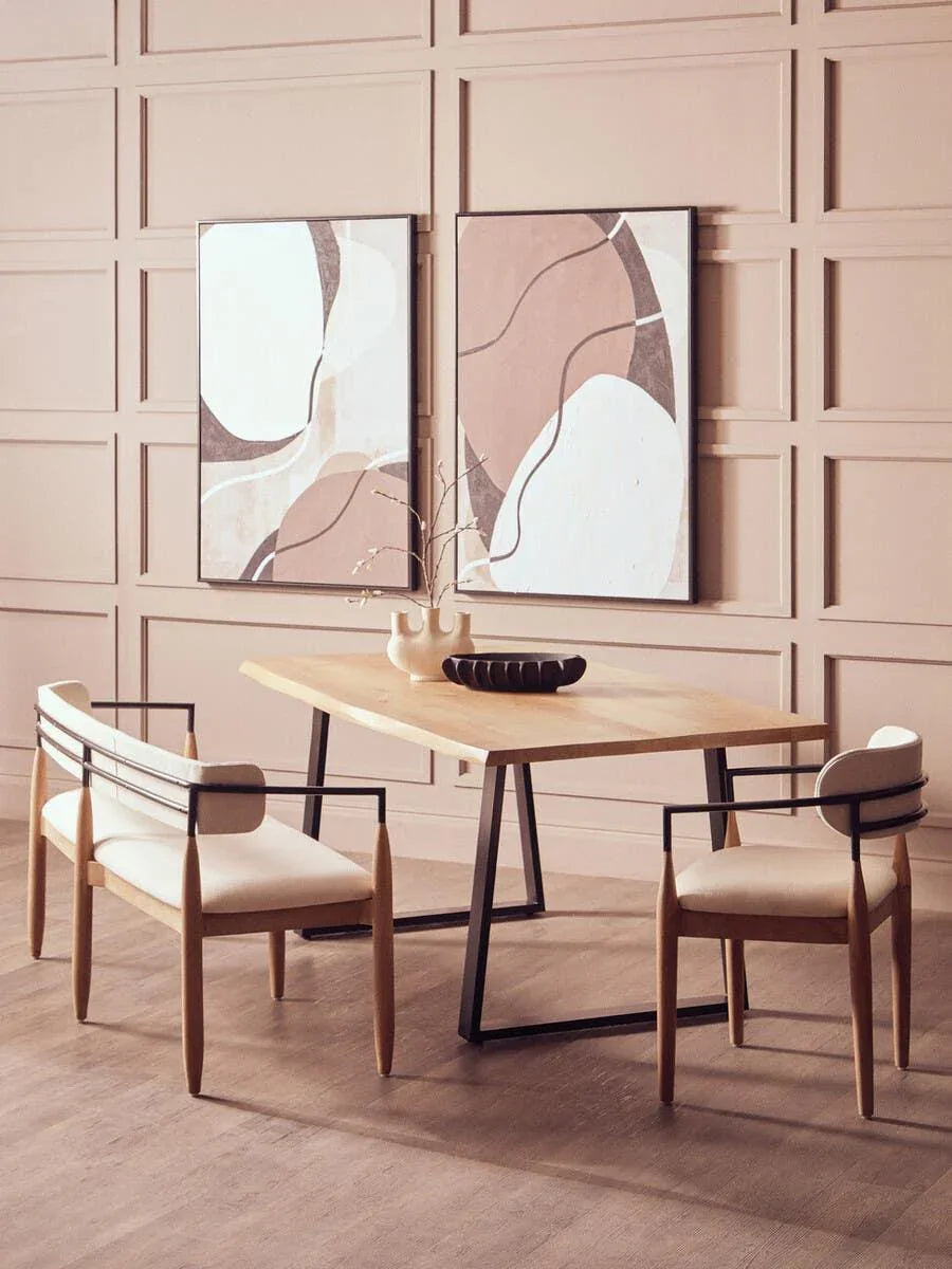 Modern dining table with light wood top, black metal legs and two cream cushioned chairs