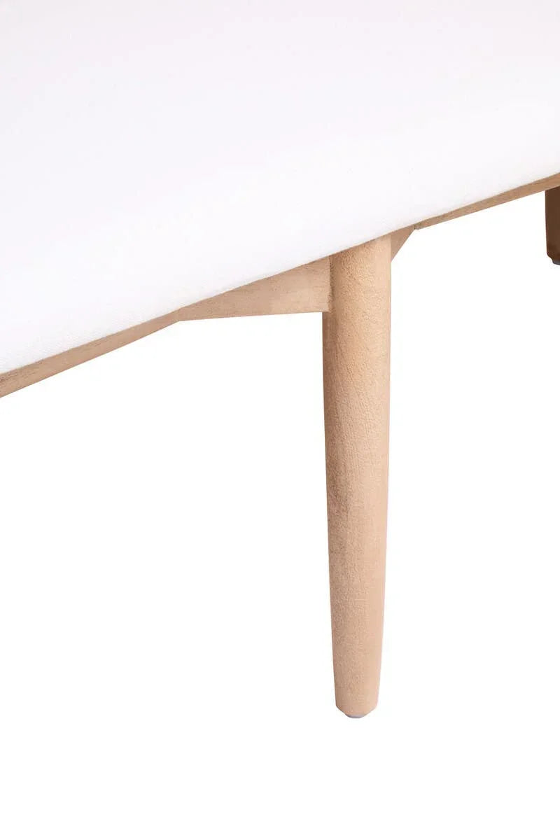 Close-up of wooden furniture leg supporting white upholstered surface