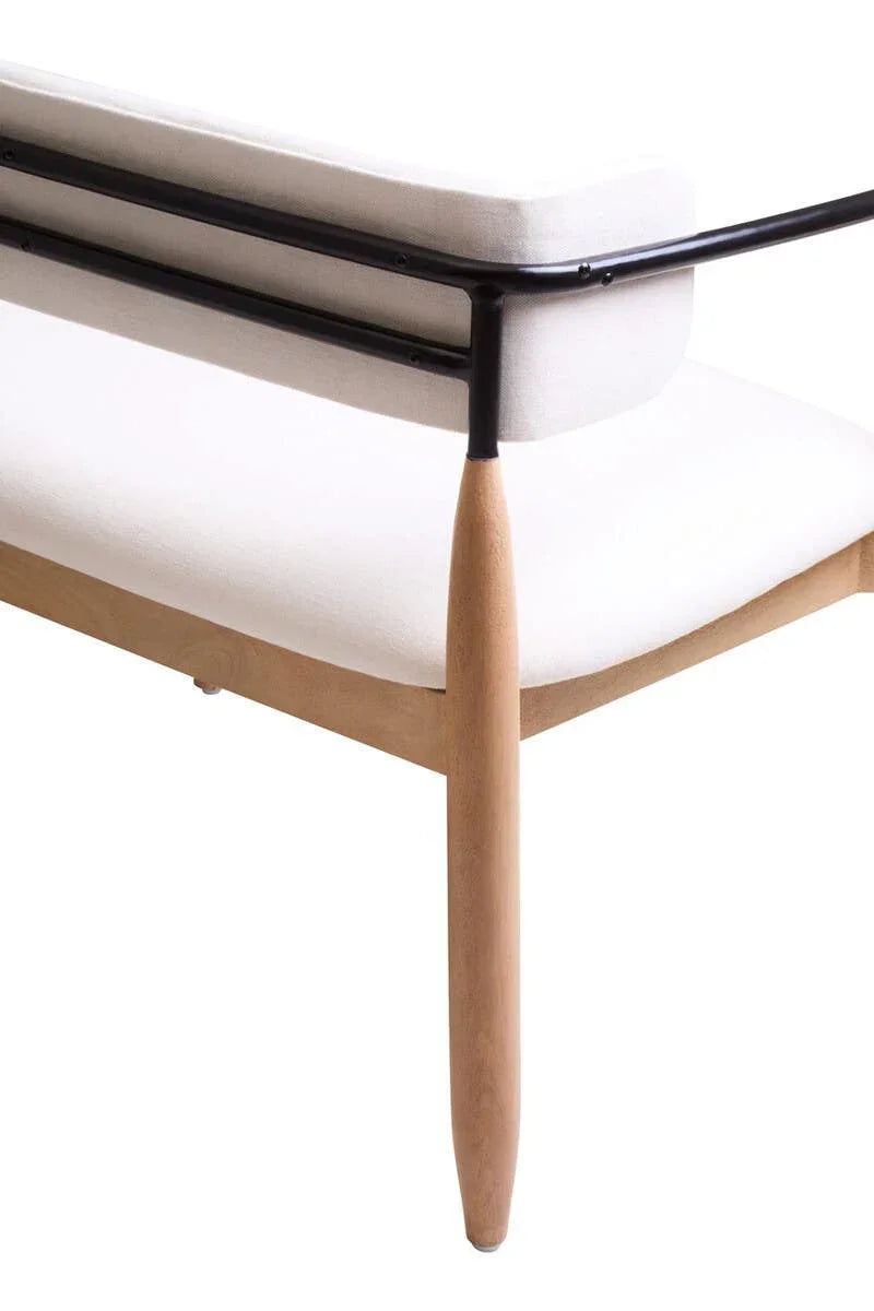 Modern sofa with white upholstery, black metal frame, and wooden legs, side angle view
