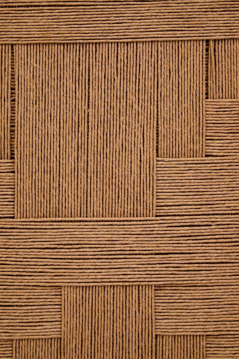 Close up of woven rattan furniture texture in natural brown, showing detailed pattern