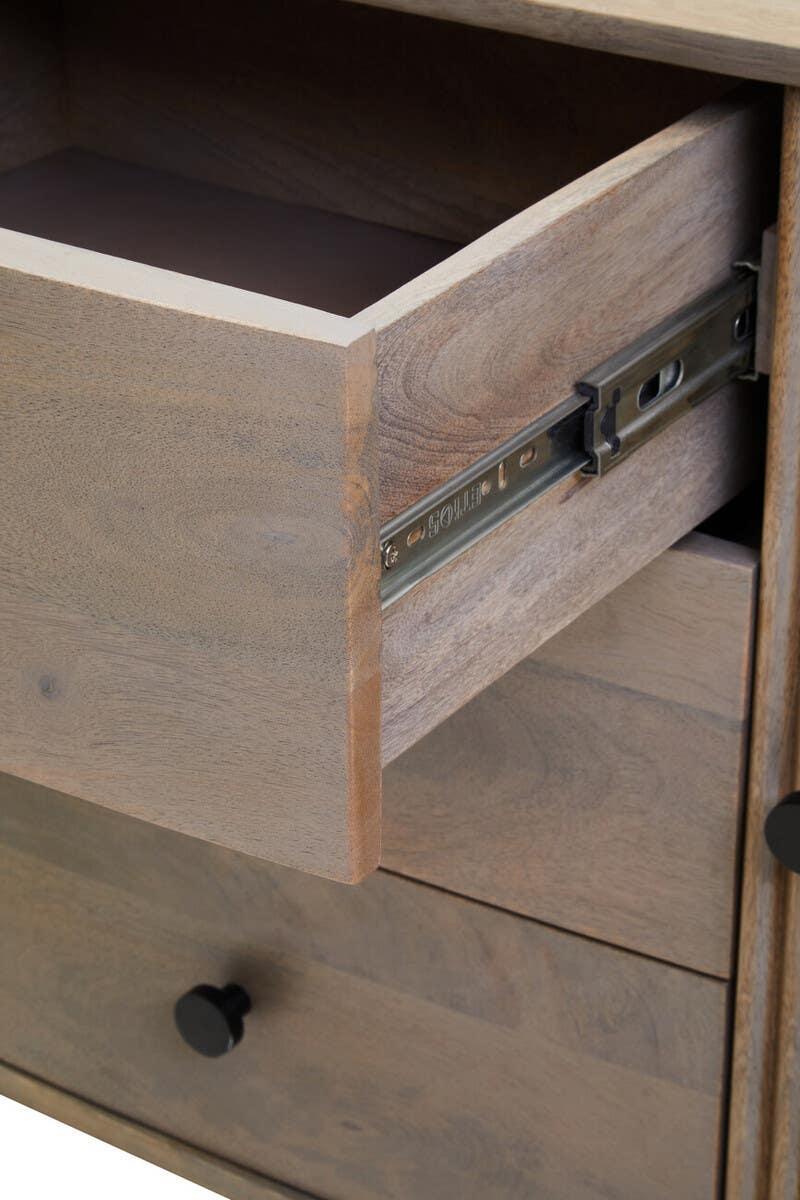 Close-up of wooden chest of drawers with metal runners and round black handles