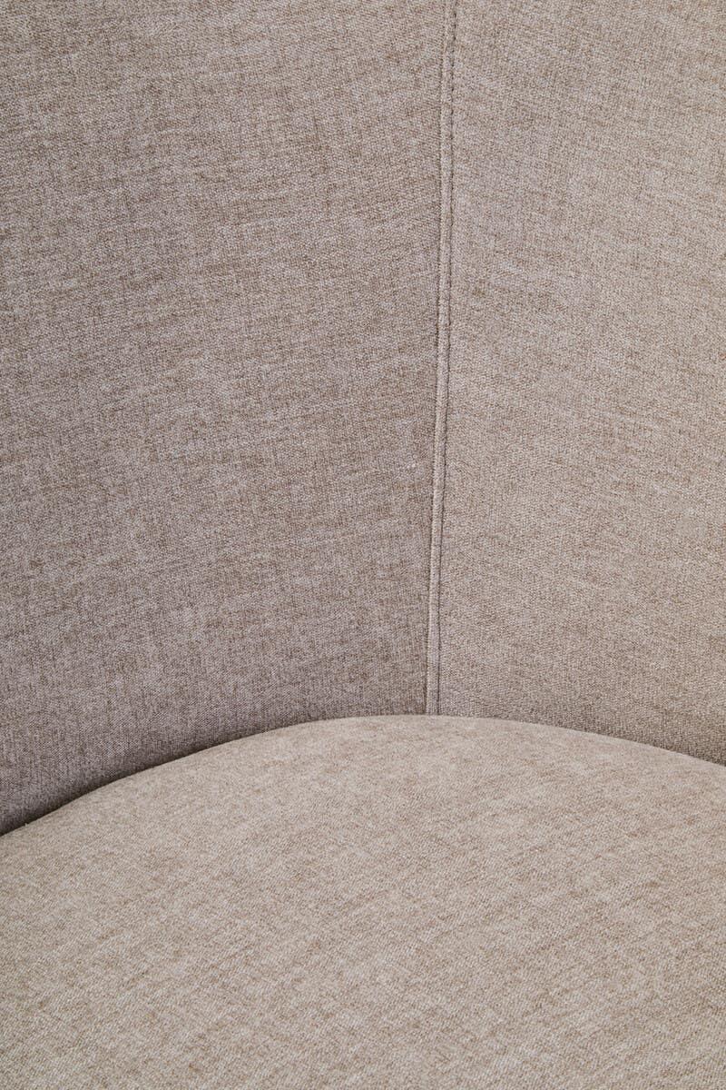 Closeup of beige fabric chair upholstery with visible stitching and curved seat